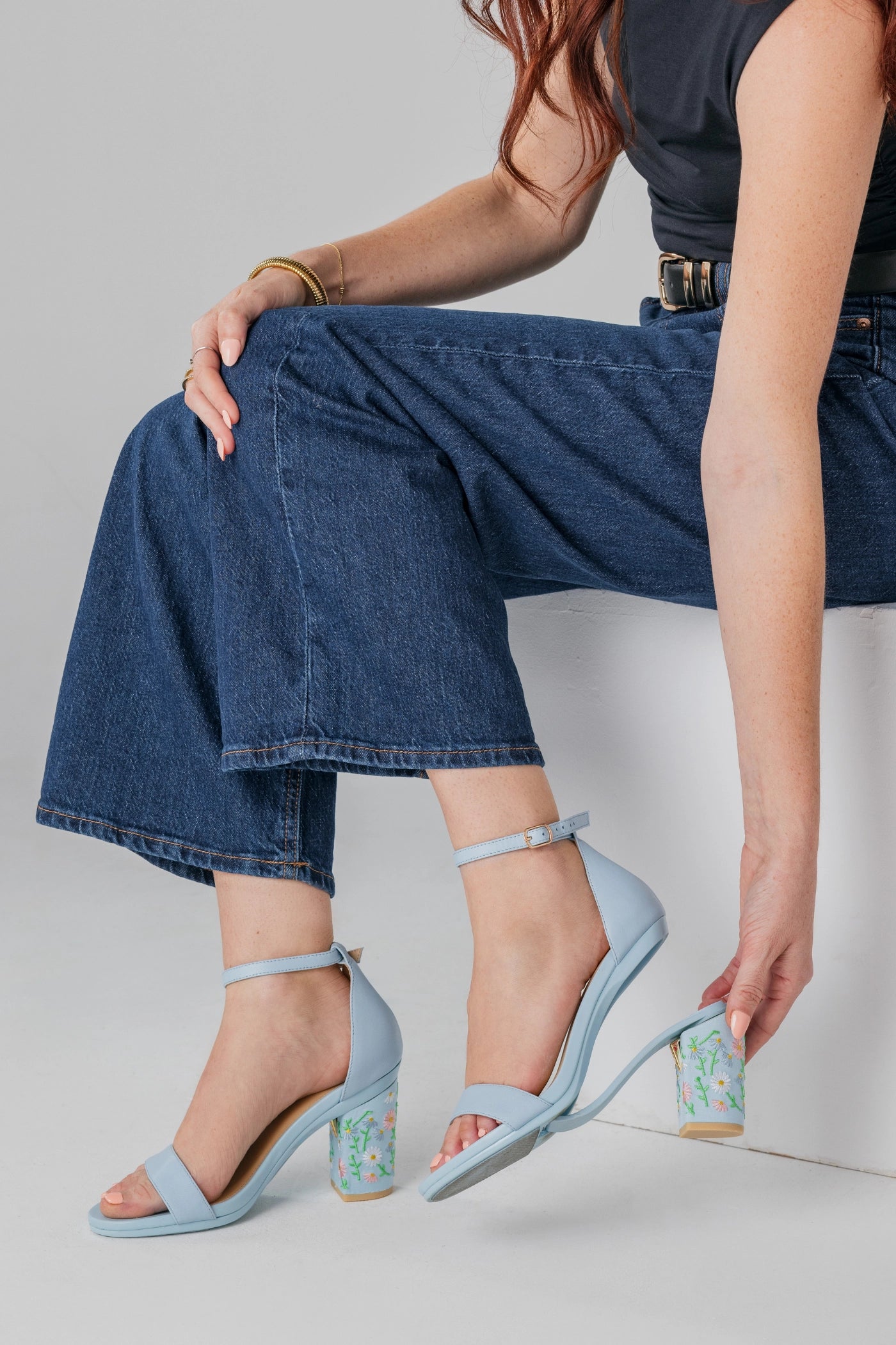 Person wearing light blue convertible high heels with floral embroidery block heels