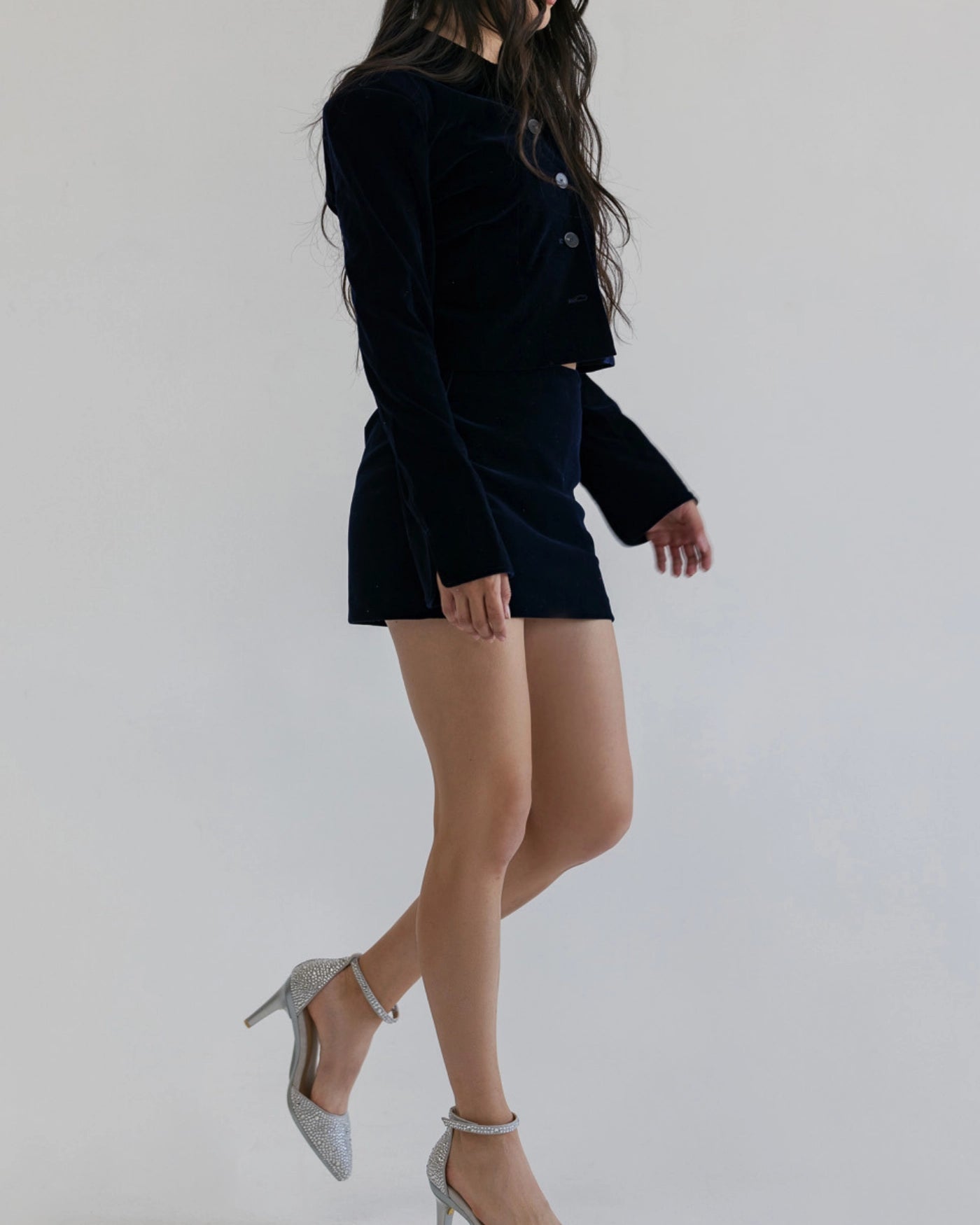 Woman wearing a black outfit with rhinestone covered silver closed toe high heels