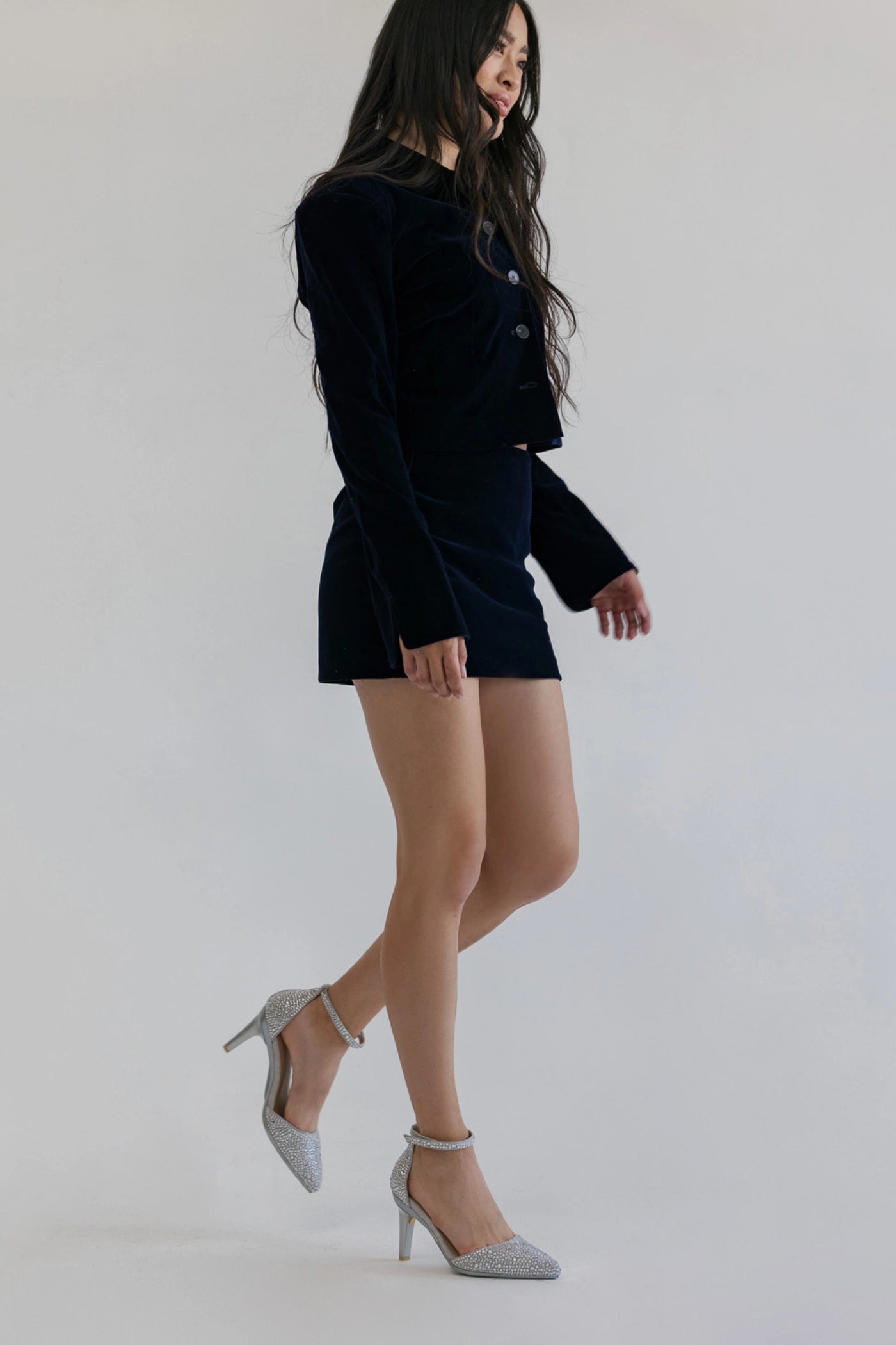 Woman wearing a black outfit with rhinestone covered silver closed toe high heels